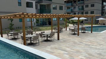 Zona de piscina con mobiliario exterior y una estructura de pérgola.