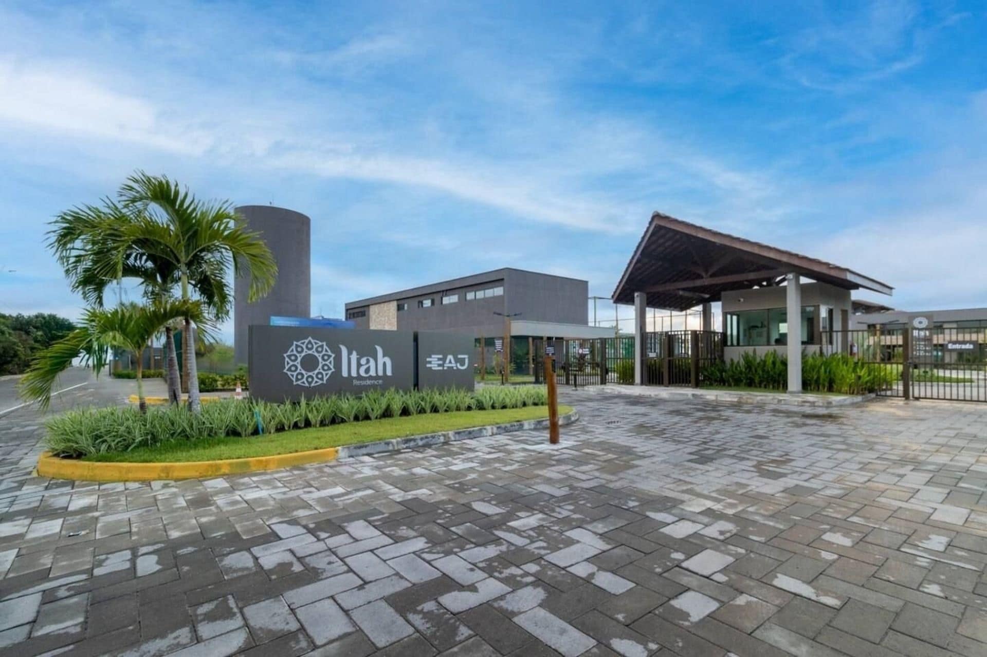 A modern hotel entrance with a sign for 'Itah Residence' and a covered walkway leading to the building.