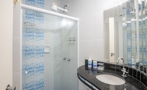 A bathroom with a glass-enclosed shower, a black countertop sink, and a mirror. - Fully Equipped Apartments in the Best Location Just Steps From the sea in Guarapari - STP (Guarapari)