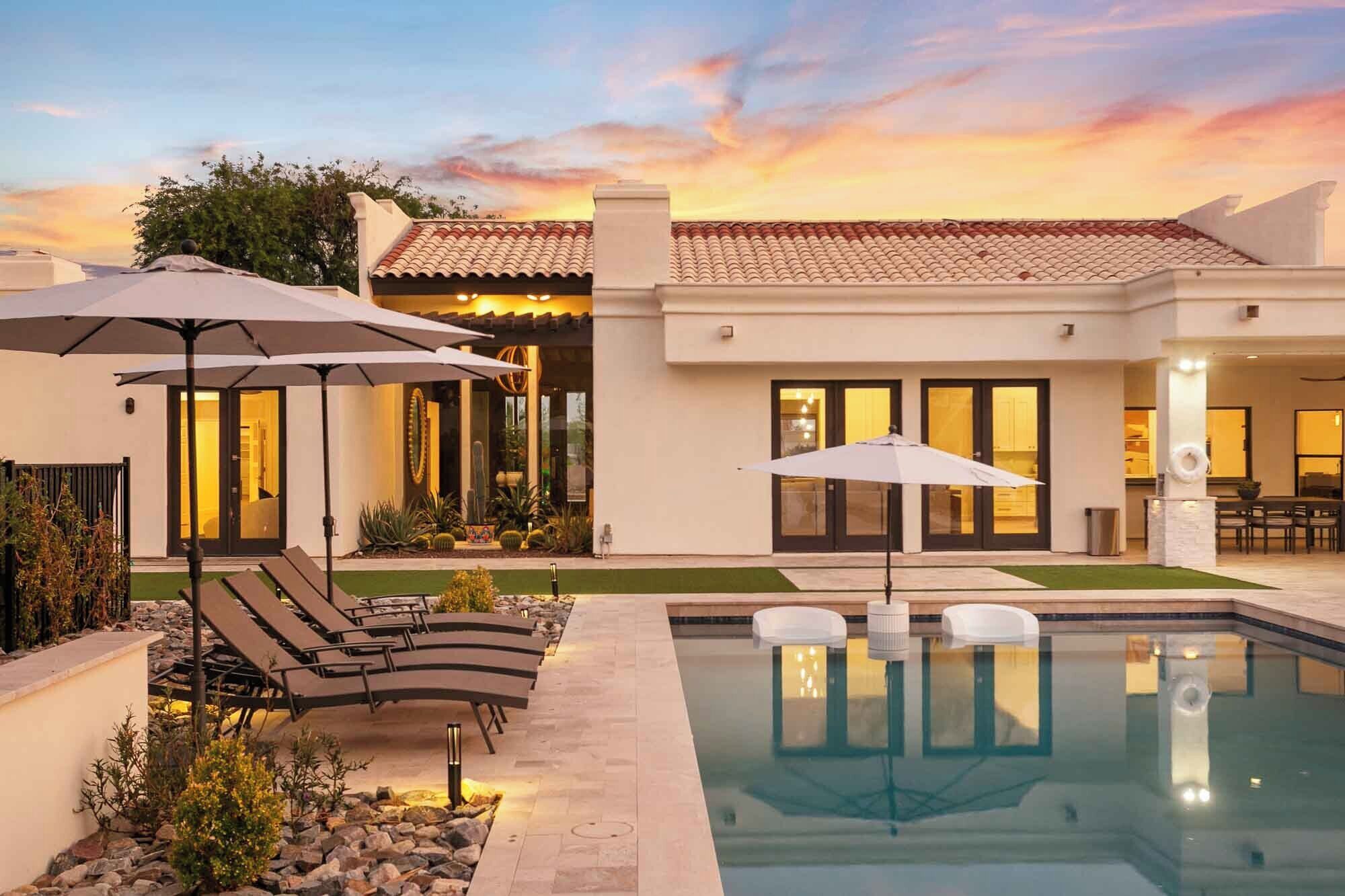 A modern house with a swimming pool, outdoor seating, and a well-maintained garden.