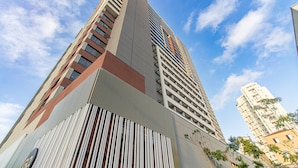 A high-rise building with a modern architectural design, featuring a prominent vertical element and a series of balconies. - Modern Studio Near Allianz Parque Sp-p2002b (São Paulo)