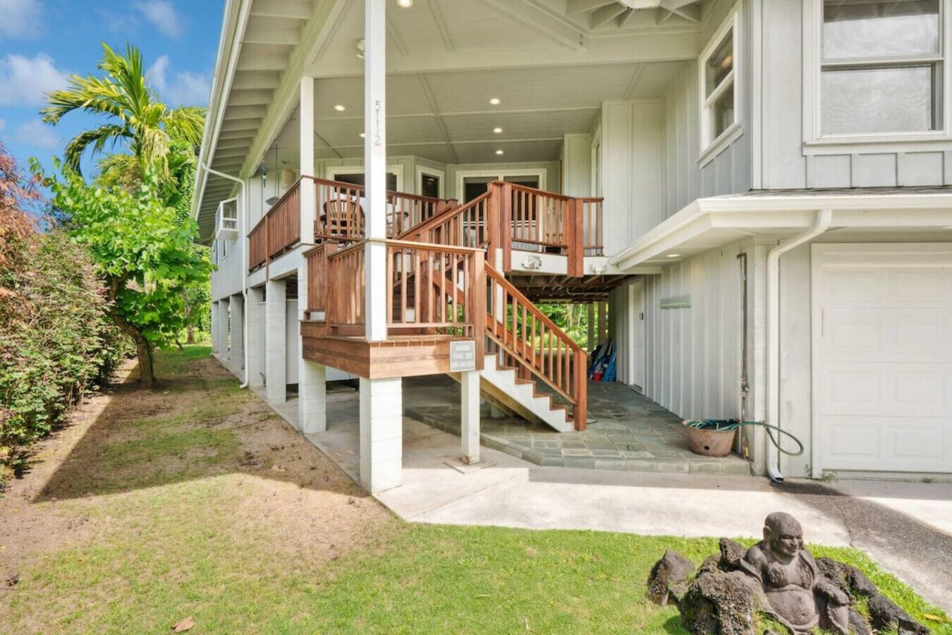 A two-story house with a covered porch, a wooden staircase, and a garage.