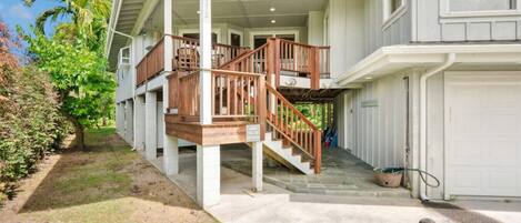 A two-story house with a covered porch, a wooden staircase, and a garage.