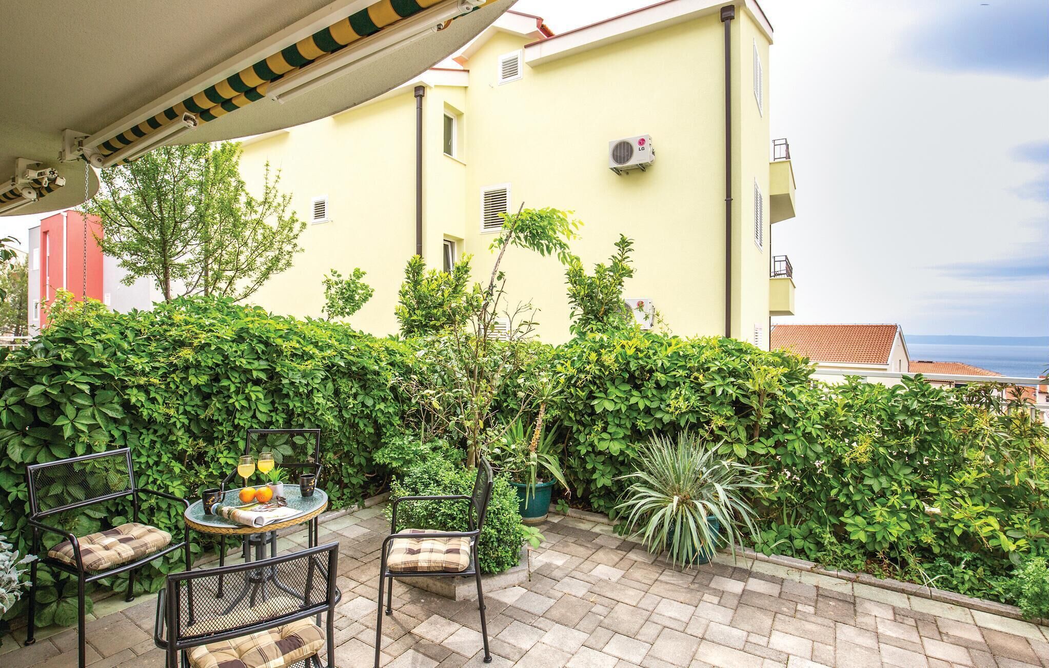 A patio with outdoor seating, a table with drinks, and a view of the sea.
