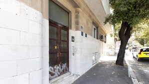 A building with a large wooden door, a small window, and a tree on the sidewalk. - 1 bedroom lovely apartment in Split (Split)