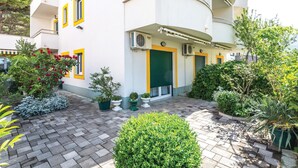 Un edificio moderno con un patio que cuenta con plantas en macetas y un pequeño jardín.