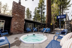 Un espace piscine doté d’un jacuzzi, de chaises longues et d’un panneau indiquant « The Iceberg Tahoe ».