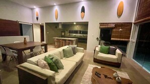 Una sala de estar con un sofá, una mesa de centro y un comedor con una mesa y sillas.