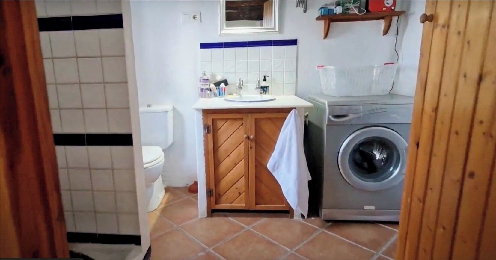 Ein kleines Badezimmer mit Toilette, Waschbecken und Waschmaschine.