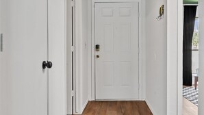 A hallway with wooden flooring, white walls, and a dark blue ceiling. - Groovy Getaway - Retro Vibes and Modern Comfort (Tulsa)