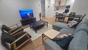 Uma sala de estar moderna com televisão, sofá e mesa de centro.
