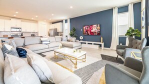 Un salon moderne avec un canapé, des fauteuils et une table basse.