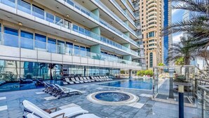 Un hôtel moderne doté d’une piscine sur le toit, avec des chaises longues et un jacuzzi.