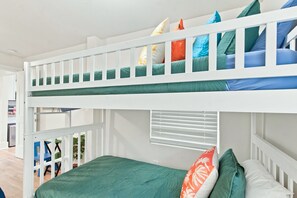 Un lit superposé avec un lit en bas et un autre lit en haut, tous deux équipés d’oreillers.