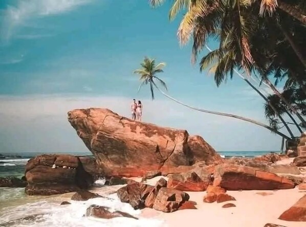 A beach with large rocks, palm trees, and a clear sky. - Amible guest home (Mirissa)