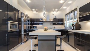 A modern kitchen with a central island, stainless steel appliances, and pendant lighting.