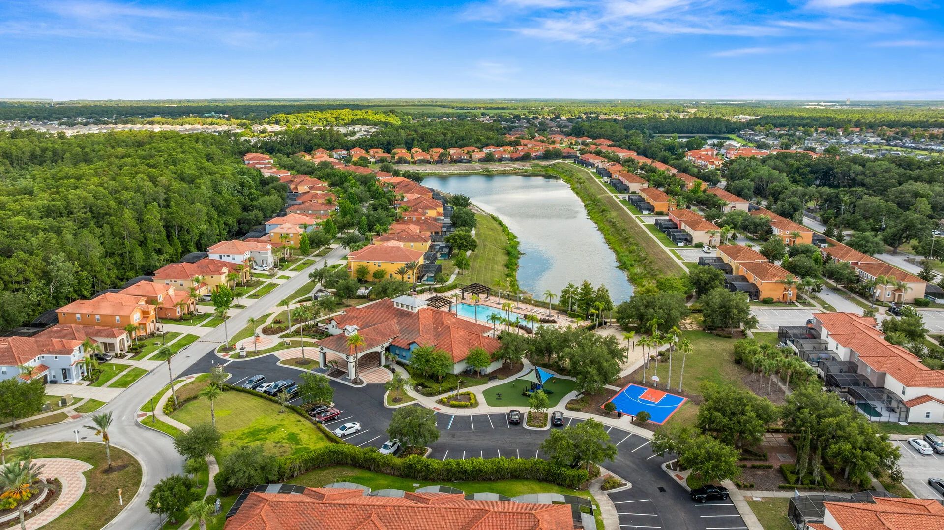 A residential area with houses, a swimming pool, and a lake.