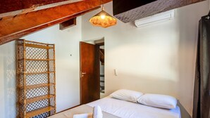Una camera da letto con un letto, una porta in legno e un lampadario.