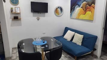 Apartamento básico, vista para o pátio | Sala de estar | TV de tela plana