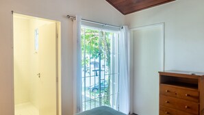 A room with a sliding glass door leading to a covered outdoor area, a wooden dresser, and a white door. - House With Barbecue 350m From the Beach Rul0035 (Ubatuba)