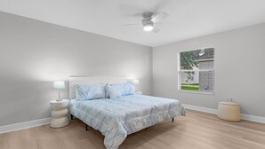A bedroom with a bed, two bedside lamps, a ceiling fan, a window with blinds, and a round bedside table. - BETTER THAN A 5 STAR HOTEL WITH GOLF CART WHOLE HOUSE TOTALLY REMODELED (The Villages)