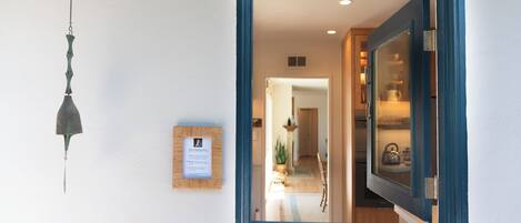 A doorway with a blue frame leading to a kitchen area with a refrigerator and a stove.