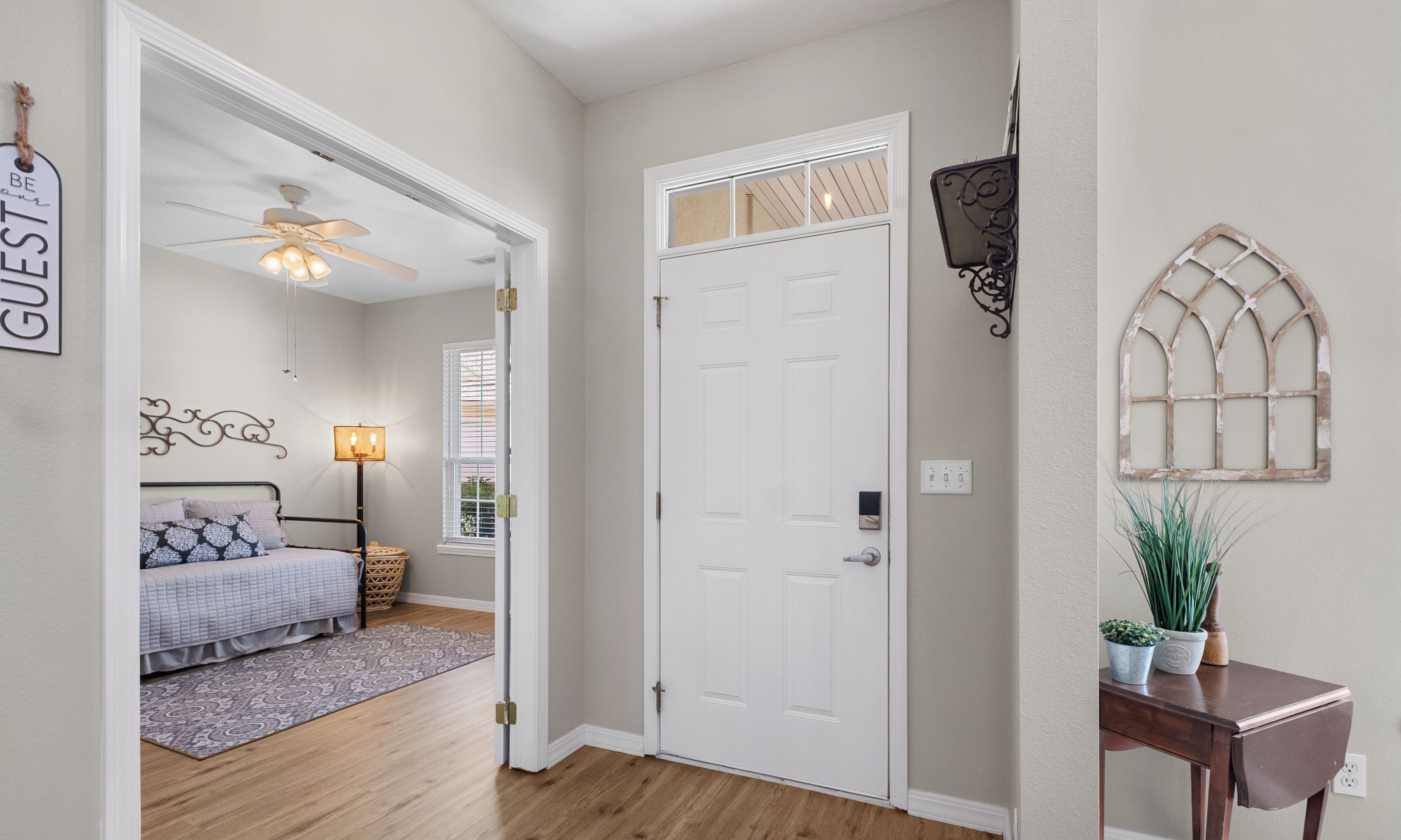A bedroom with a bed, bedside table, and a ceiling fan.