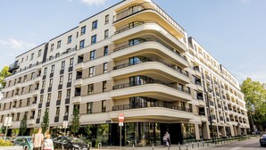 Un immeuble à plusieurs étages, doté de balcons, de grandes fenêtres et d’un panneau indiquant qu’il est interdit d’y entrer.