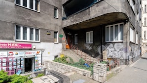 Un bâtiment avec une devanture visible, un escalier menant à un étage supérieur et un mur couvert de graffitis.