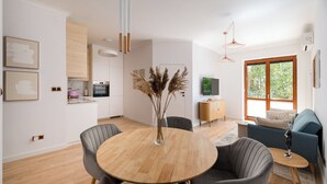 Un espace de vie moderne comprenant un coin repas, une cuisine et un coin salon.