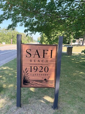 A wooden signboard with the text 'SAFI BEACH 1920 LAKESHORE' mounted on two poles. - Lakeview studio in enchanting Port Sanilac with AC (Port Sanilac)