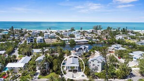Un quartier résidentiel situé sur la côte, avec des maisons, un port de plaisance et une vue dégagée sur l’océan.