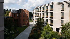 Un bâtiment moderne avec une façade en briques et une structure blanche agrémentée de balcons.