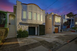 Une maison à deux étages avec un garage, une cour avant et une vue sur la rue.