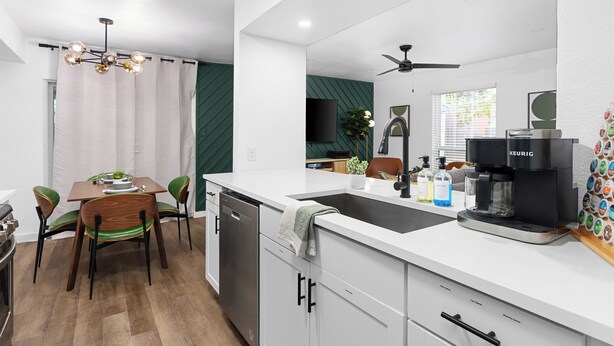 A modern kitchen with a dishwasher, a coffee maker, and a dining area with a table and chairs. - Prime Location Zilker Park & SoCo Chic (Austin)