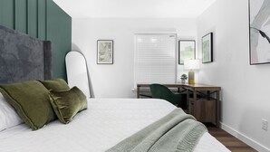 A modern bedroom with a bed, green pillows, a desk, and a chair. - Prime Location Zilker Park & SoCo Chic (Austin)