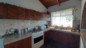 Una cocina con armarios de madera, estufa a gas, microondas y un lavabo.