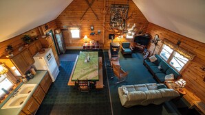 A cozy attic room with a dining table, seating area, and kitchen. - Secluded Woodland Retreat Surrounded by Forest Views & Wildlife (Mill Hall)