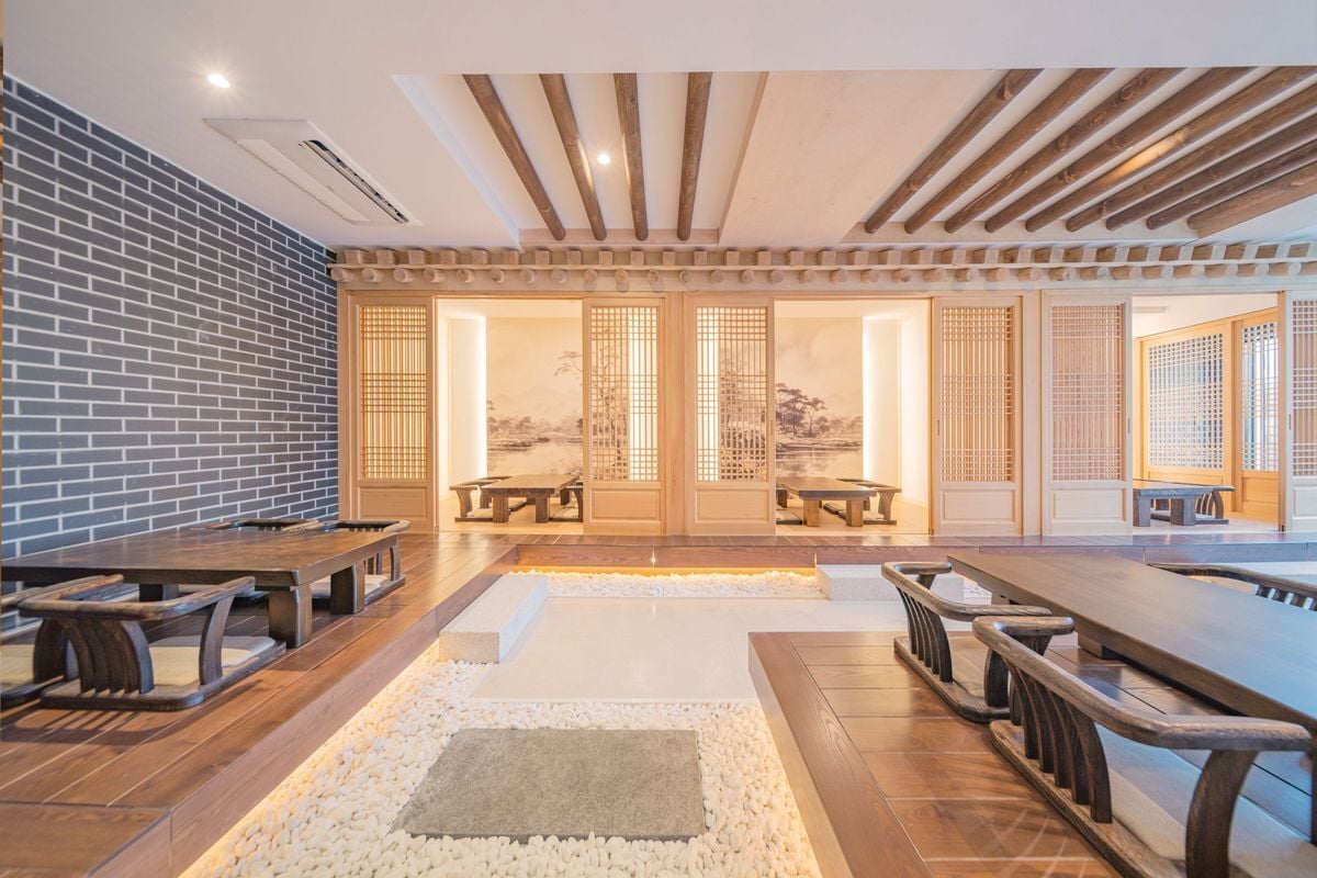 Een kamer in traditionele stijl met houten banken, een stenen pad en uitzicht door een shoji-scherm.
