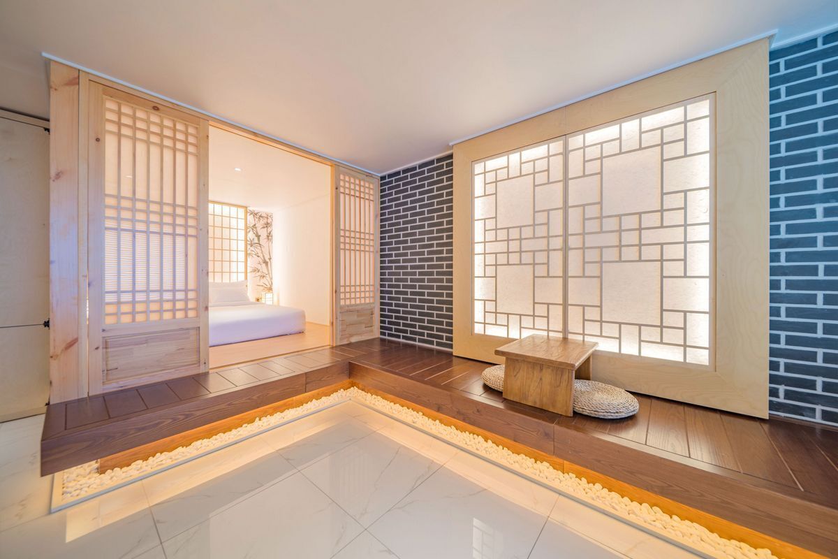 A traditional Japanese interior with sliding doors, a wooden bench, and a tiled floor.