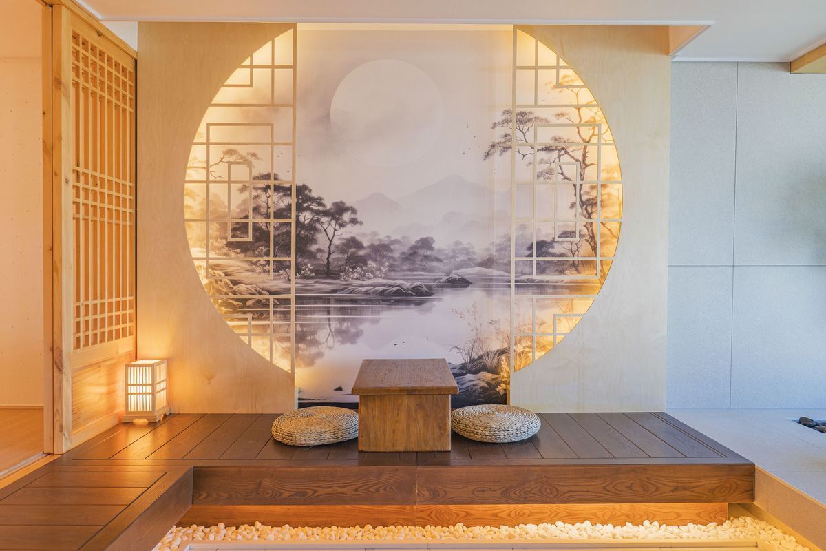 Een traditionele Japanse kamer met tatami vloerbedekking, een lage houten tafel en een rond scherm waarop een vredig landschap wordt getoond.