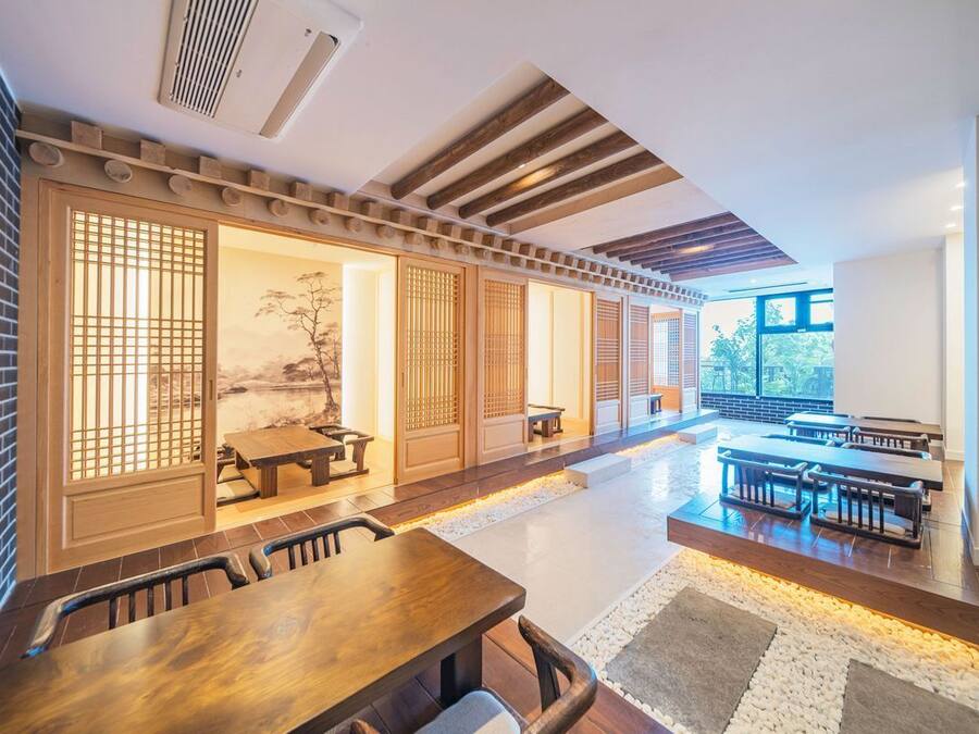 A traditional Japanese-style restaurant with wooden sliding doors, tatami mats, and a view of the outdoors.