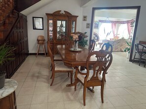 A dining area with a wooden table and chairs, a cabinet with glass doors, and a staircase. - Large House With View To Lake Atitlan (Panajachel)