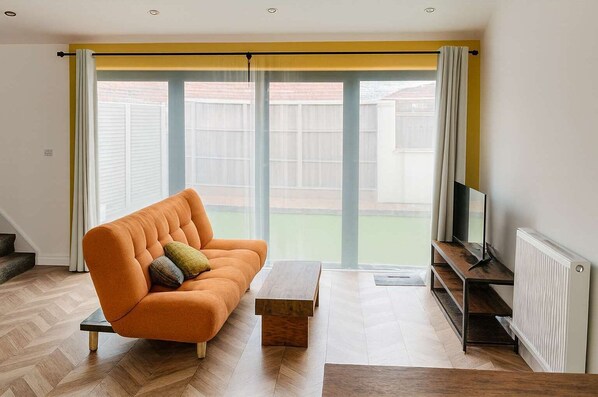 Ein modernes Wohnzimmer mit einer Couch, einem Couchtisch und einem Fernseher.