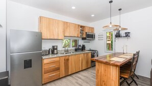 A modern kitchen with wooden cabinets, stainless steel appliances, and a central island with chairs.