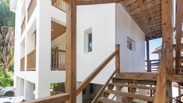 A multi-story building with wooden balconies and a staircase.
