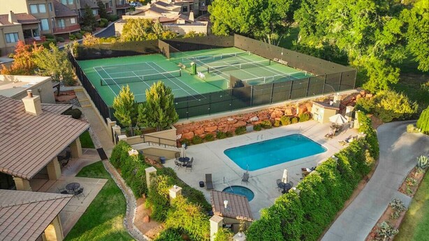 Asuinrakennus, jossa on tenniskenttä, uima-allas ja patio.