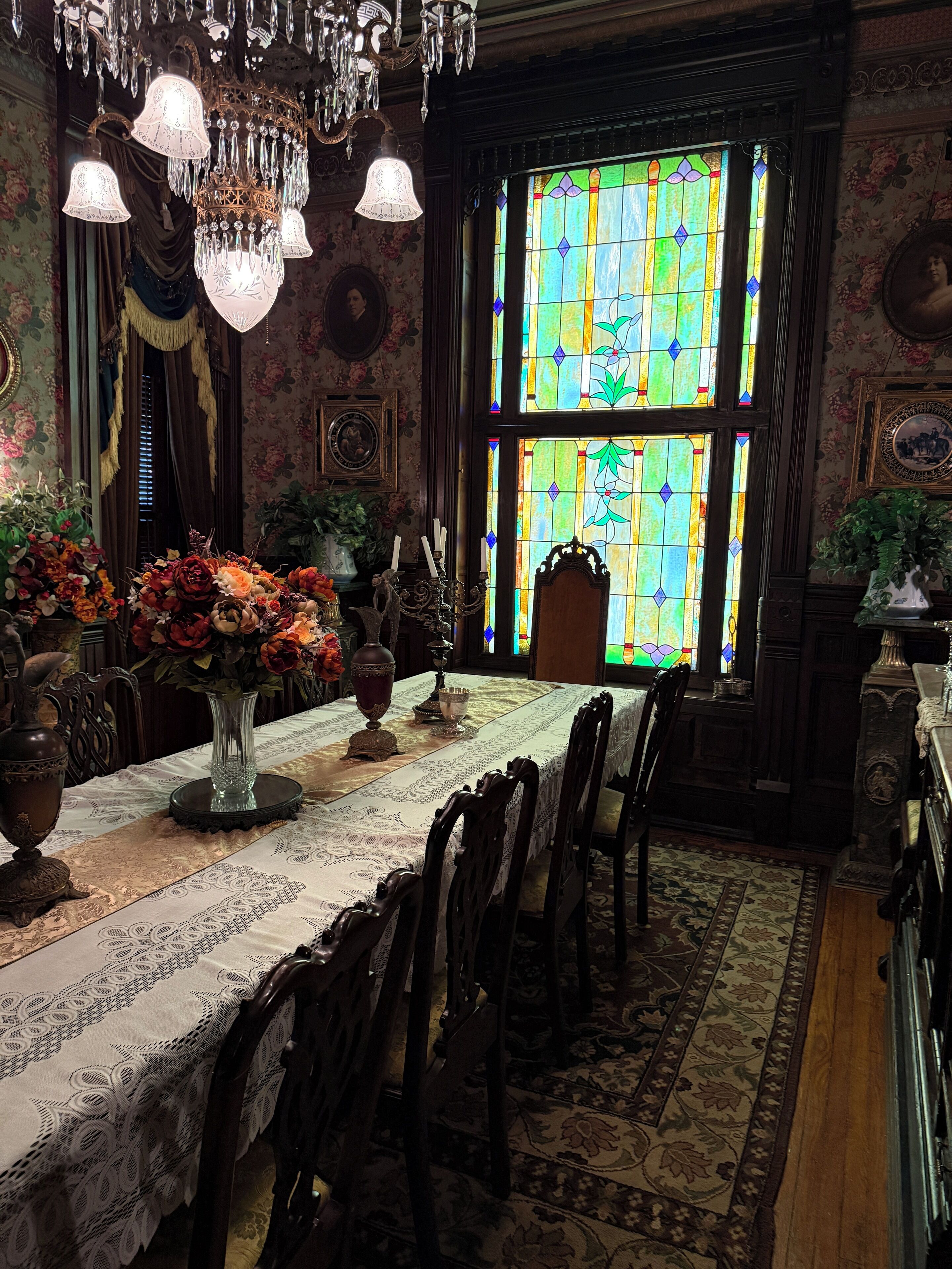 Un comedor con una mesa larga dispuesta para una comida, rodeada de sillas.