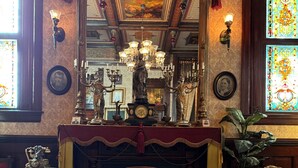 A room with a fireplace, ornate decorations, and a glass coffee table. - The Stegmaier Guest House (Wilkes-Barre)