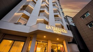 A modern hotel with a prominent entrance, large windows, and a well-lit facade. - POHANG HOTEL LA TERRACE (Pohang)